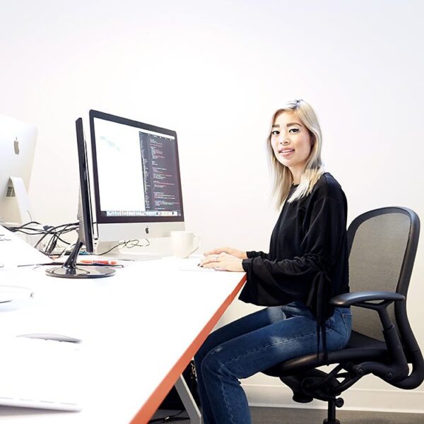 Woman sitting in front of a computer and coding.